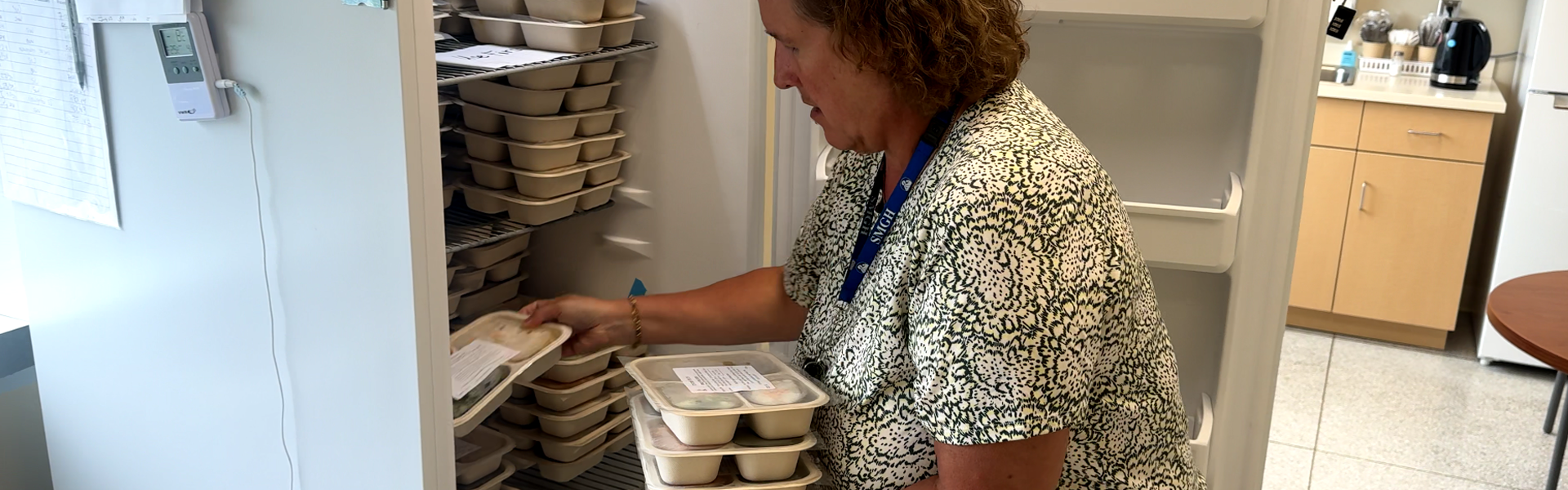 Tracey Ostermann stocking the freezer with meals for patients in need